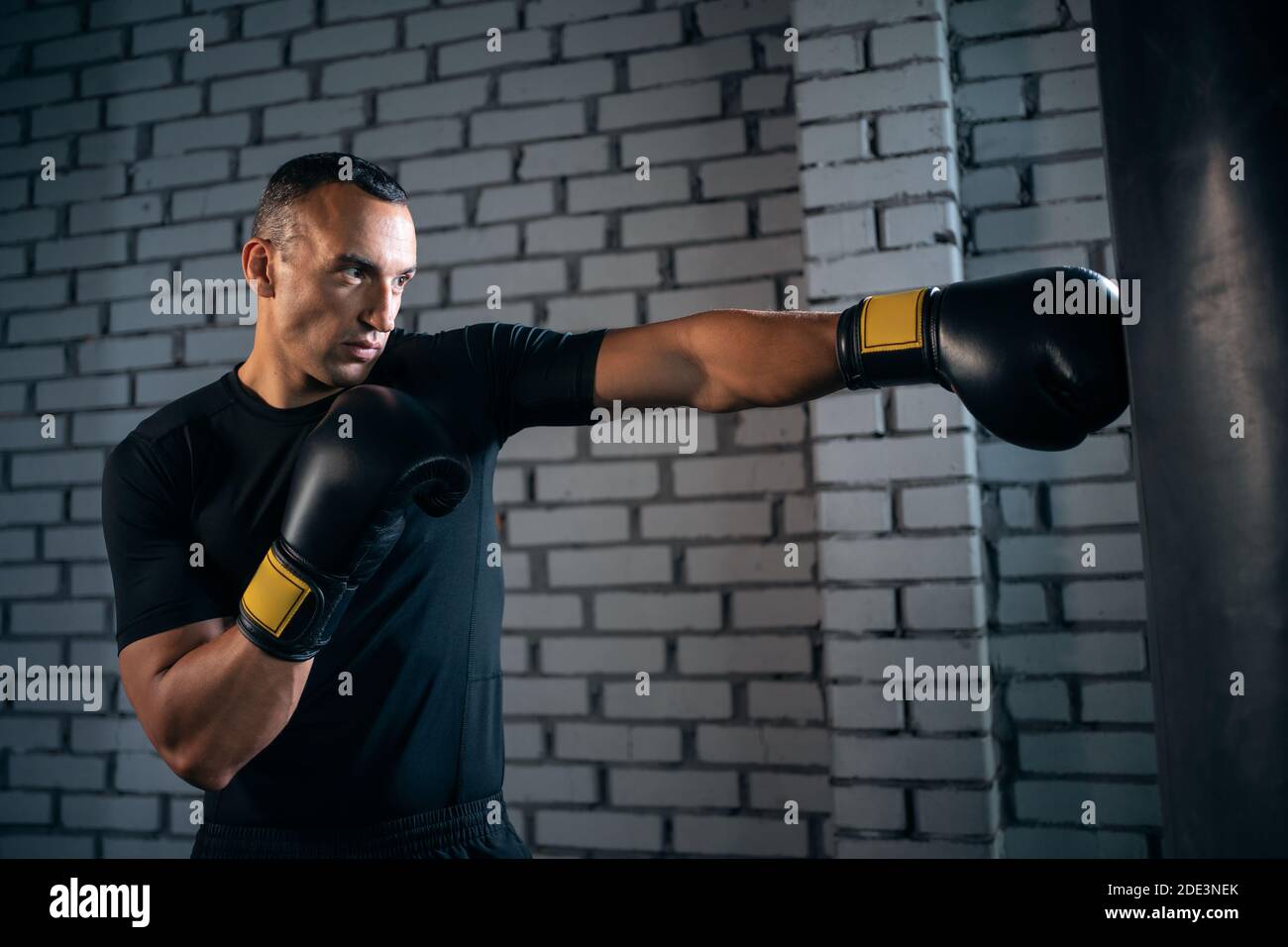 athletic sport man boxer training with punching bag or exercising in gym Stock Photo