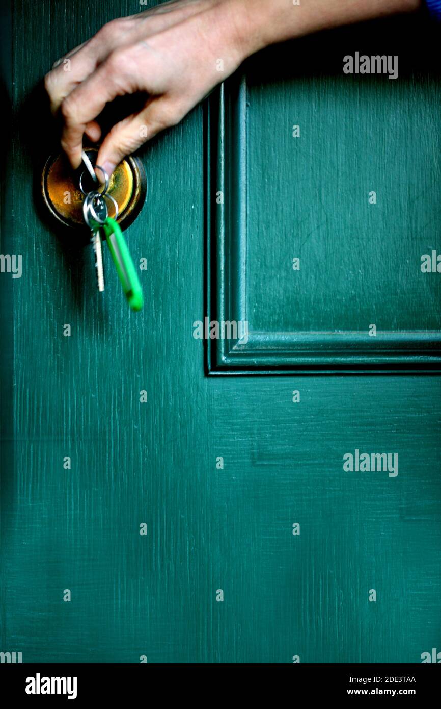 A hand opening the green house door with a key Stock Photo - Alamy