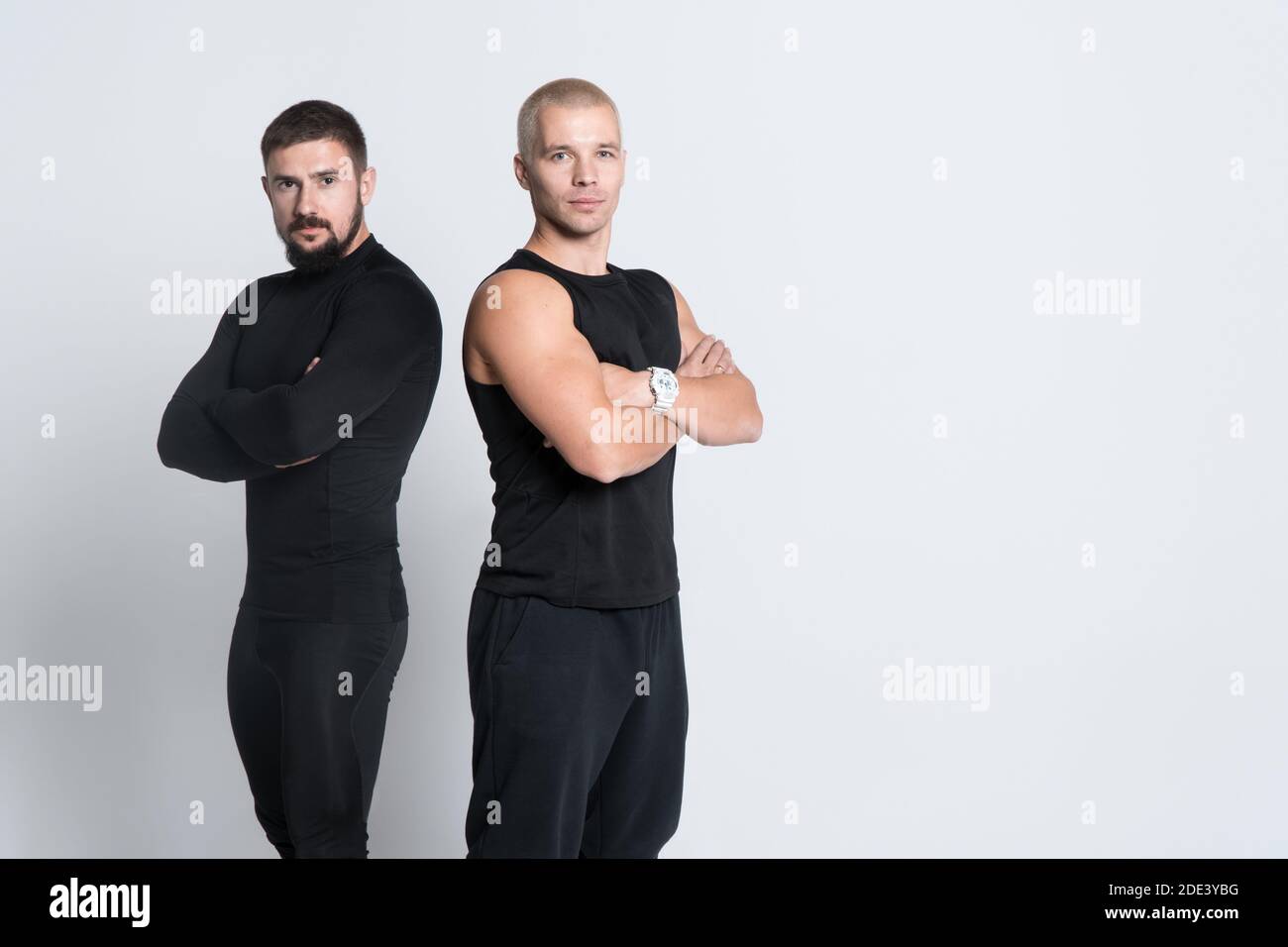 two athletic personal fitness trainers or bodybuilders on white background Stock Photo