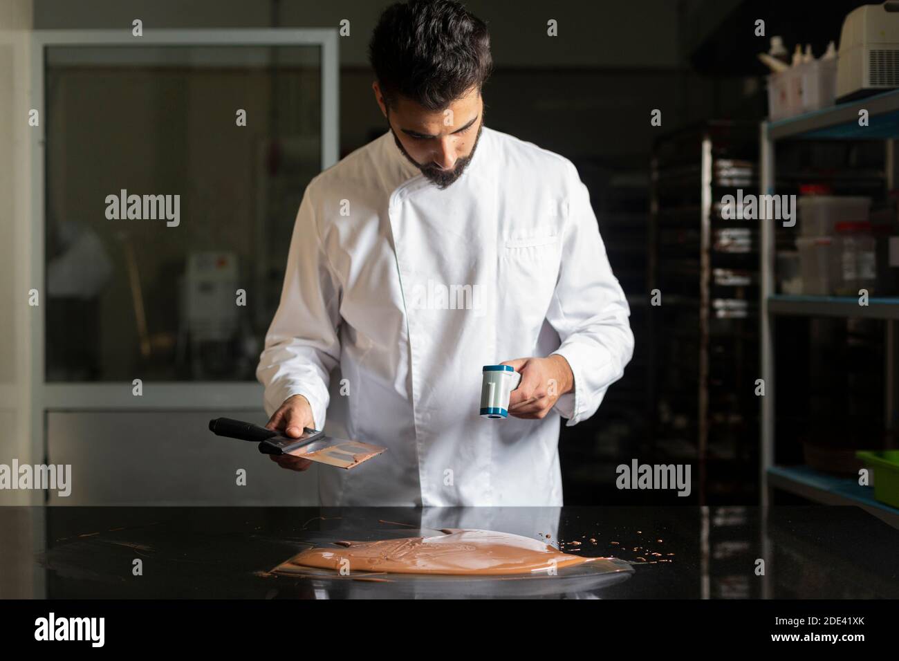 https://c8.alamy.com/comp/2DE41XK/pastry-chef-measuring-the-temperature-of-the-chocolate-with-an-infrared-thermometer-working-on-the-tempering-of-the-chocolate-2DE41XK.jpg