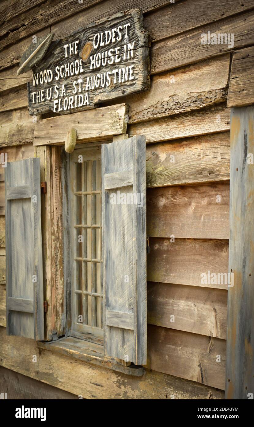 A close up of signage and window of a restored building proclaims it to be the oldest wood school house in the USA, St. Augustine, FL Stock Photo