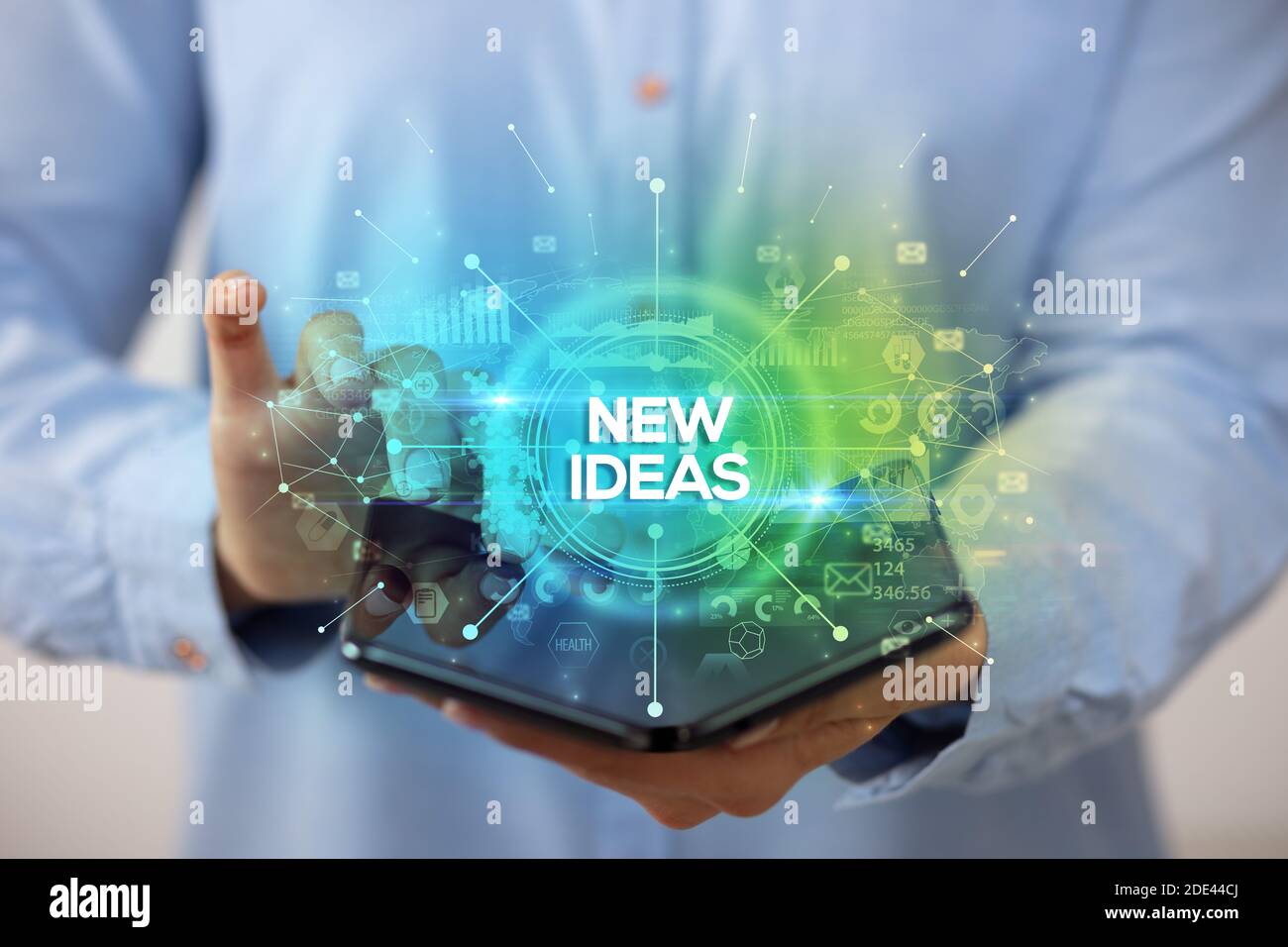 Businessman holding a foldable smartphone with NEW IDEAS inscription, new business concept Stock Photo