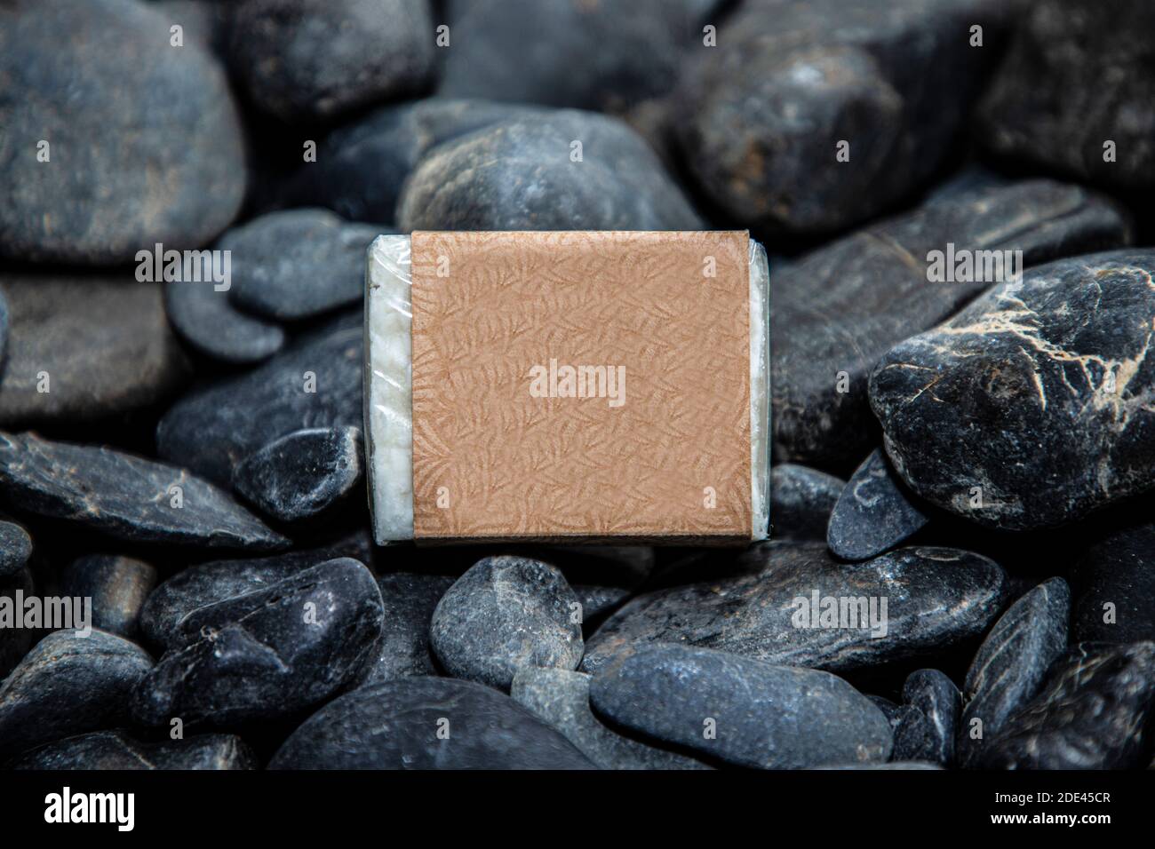 Natural beige soap on some dark rocks Stock Photo