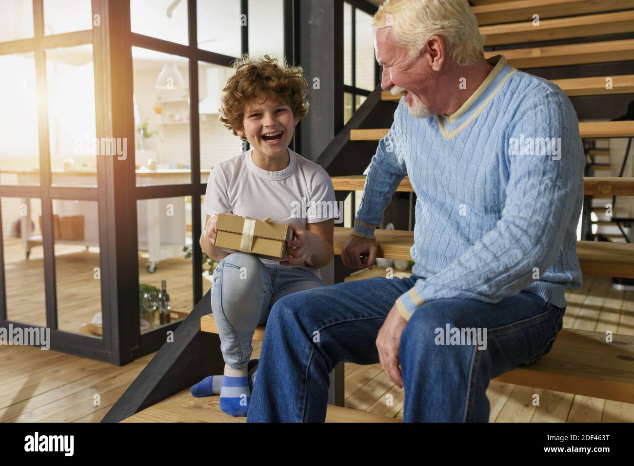 Happy grandson receives a gift from grandfather. joyful expression