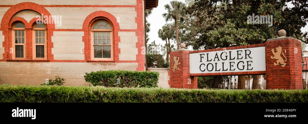 A Panoramic format close up view of the historical landmark of the Flagler College sign with red brick columns and the historical Spanish Renaissance Stock Photo