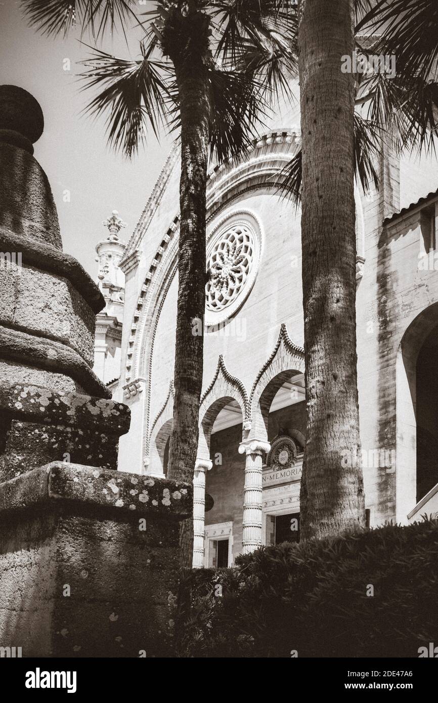 View through palm tree trunks of moorish style arches and pillars leading to entrance for the Memorial Presbyterian Church in St. Augustine, FL in bro Stock Photo