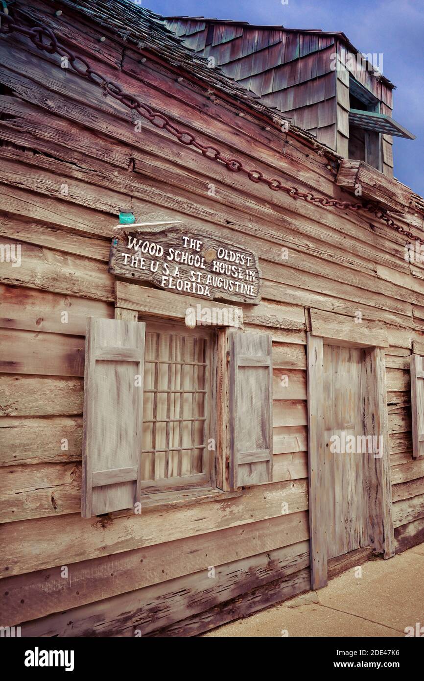 A sign attached above window of primitive building proclaims to be the oldest wood school house in the USA, attracting tourists in St. Augustine, FL Stock Photo