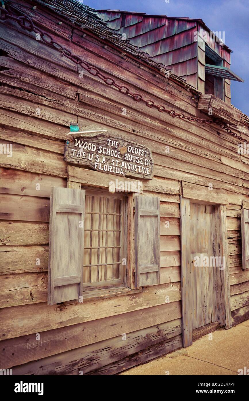 A sign attached above window of primitive building proclaims to be the oldest wood school house in the USA, attracting tourists in St. Augustine, FL Stock Photo