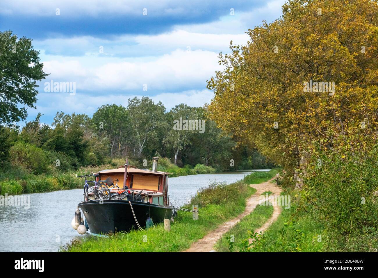 The Canal du Midi, near Carcassonne, French department of Aude, Occitanie Region, Languedoc-Rousillon France. Boats moored on the tree lined canal. Stock Photo