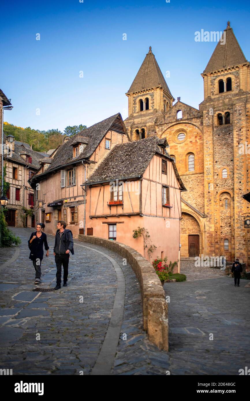 The small medieval village of Conques in France. It shows visitors its abbey-church and clustered houses topped by slate roofs.  Crossing of narrow st Stock Photo