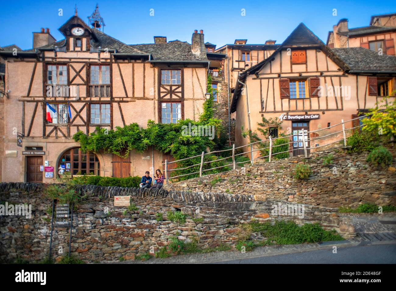 The small medieval village of Conques in France. It shows visitors its abbey-church and clustered houses topped by slate roofs.  Crossing of narrow st Stock Photo