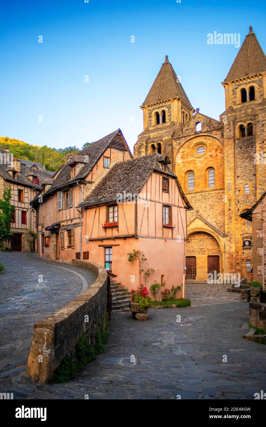 The small medieval village of Conques in France. It shows visitors its abbey-church and clustered houses topped by slate roofs.  Crossing of narrow st Stock Photo