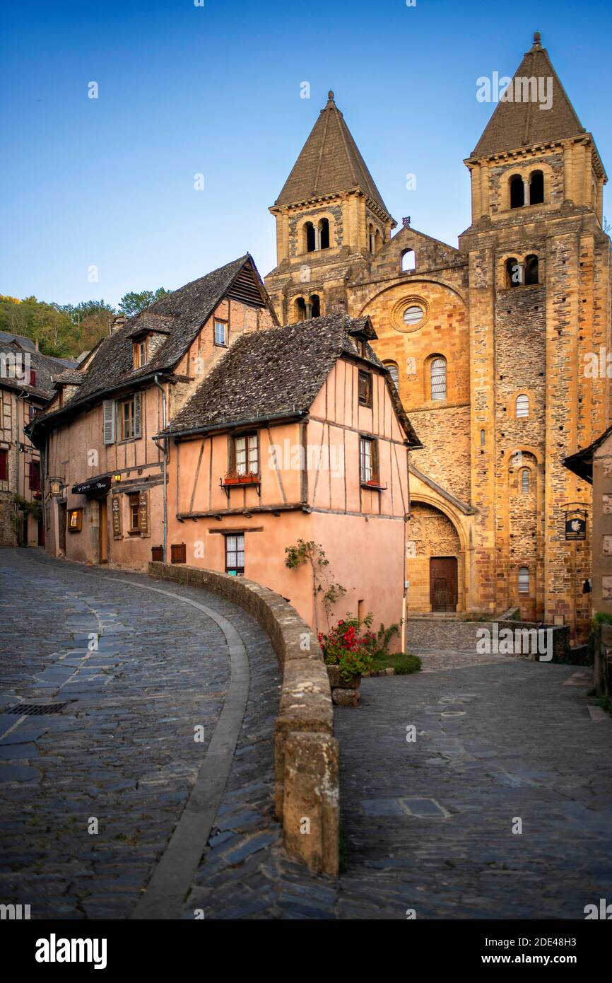 The small medieval village of Conques in France. It shows visitors its abbey-church and clustered houses topped by slate roofs.  Crossing of narrow st Stock Photo