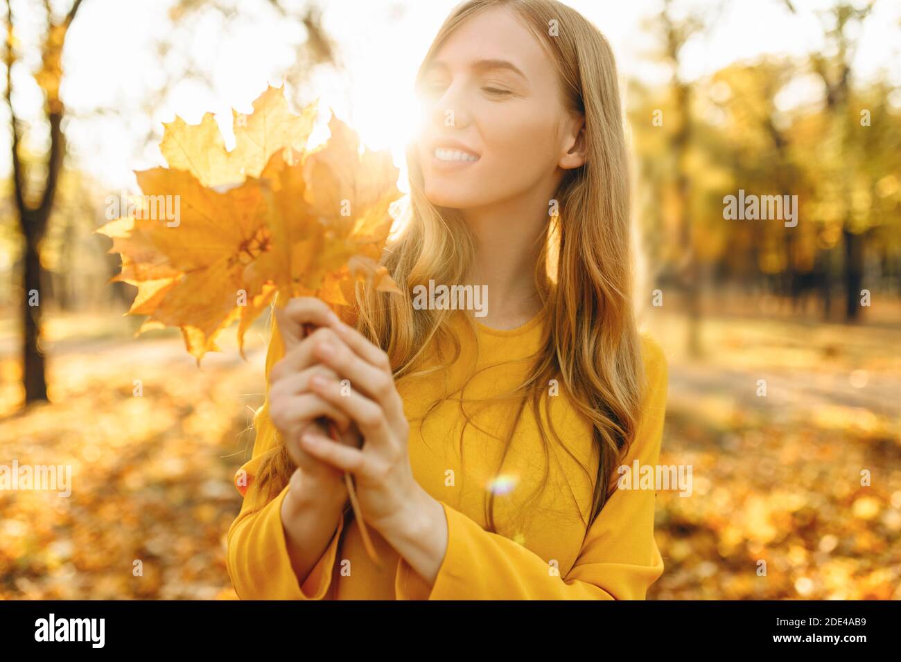 Portrait of a beautiful happy woman with a smile with autumn yellow ...