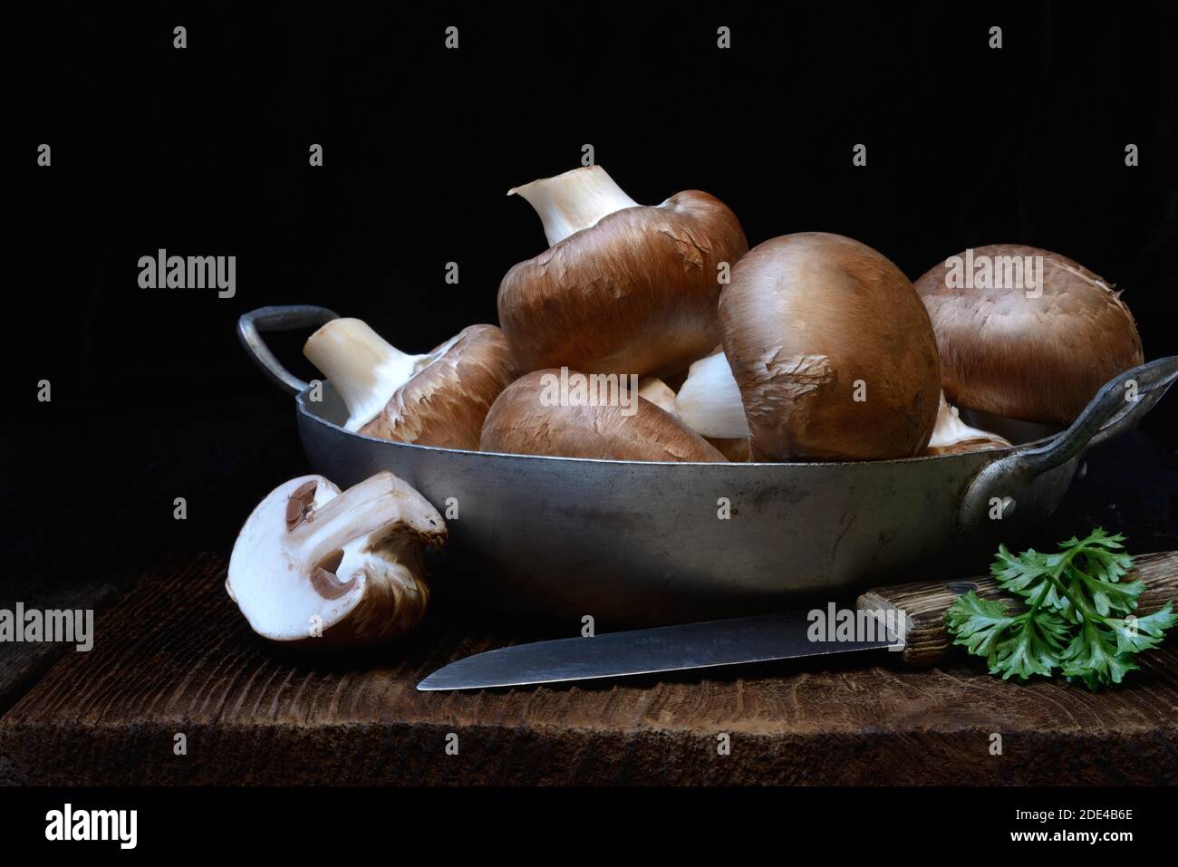 Brown cultivated mushrooms in shell with knife, Germany Stock Photo