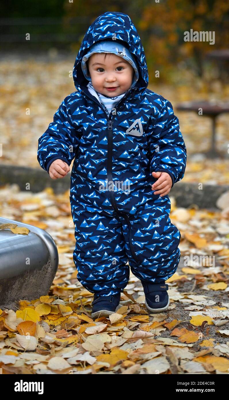 Toddler, boy, 15 months, multiethnic, in autumn leaves, laughs, Stuttgart, Baden-Wuerttemberg, Germany Stock Photo