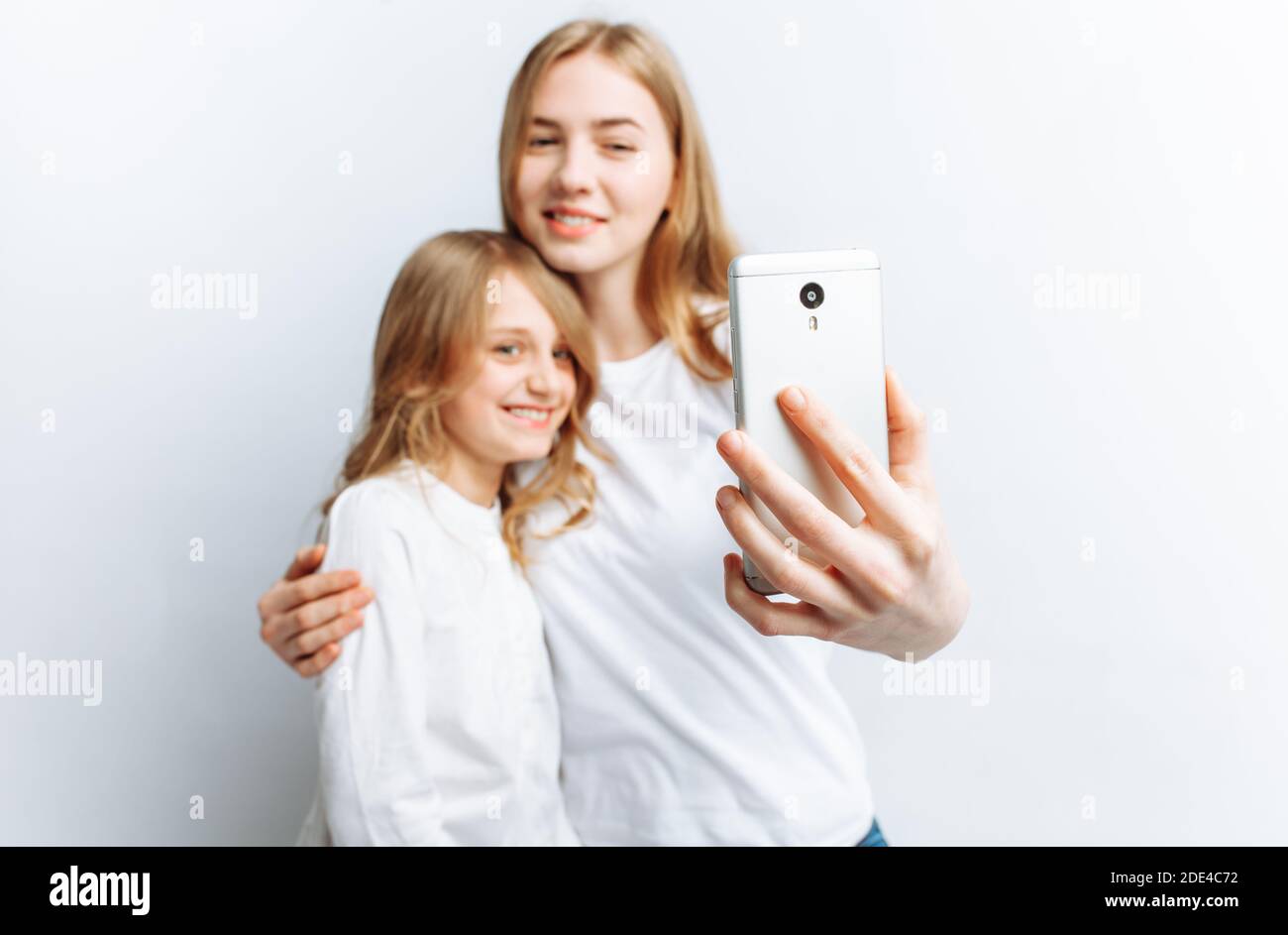 Mom or older sister makes selfie little girl, happy family, photo ...