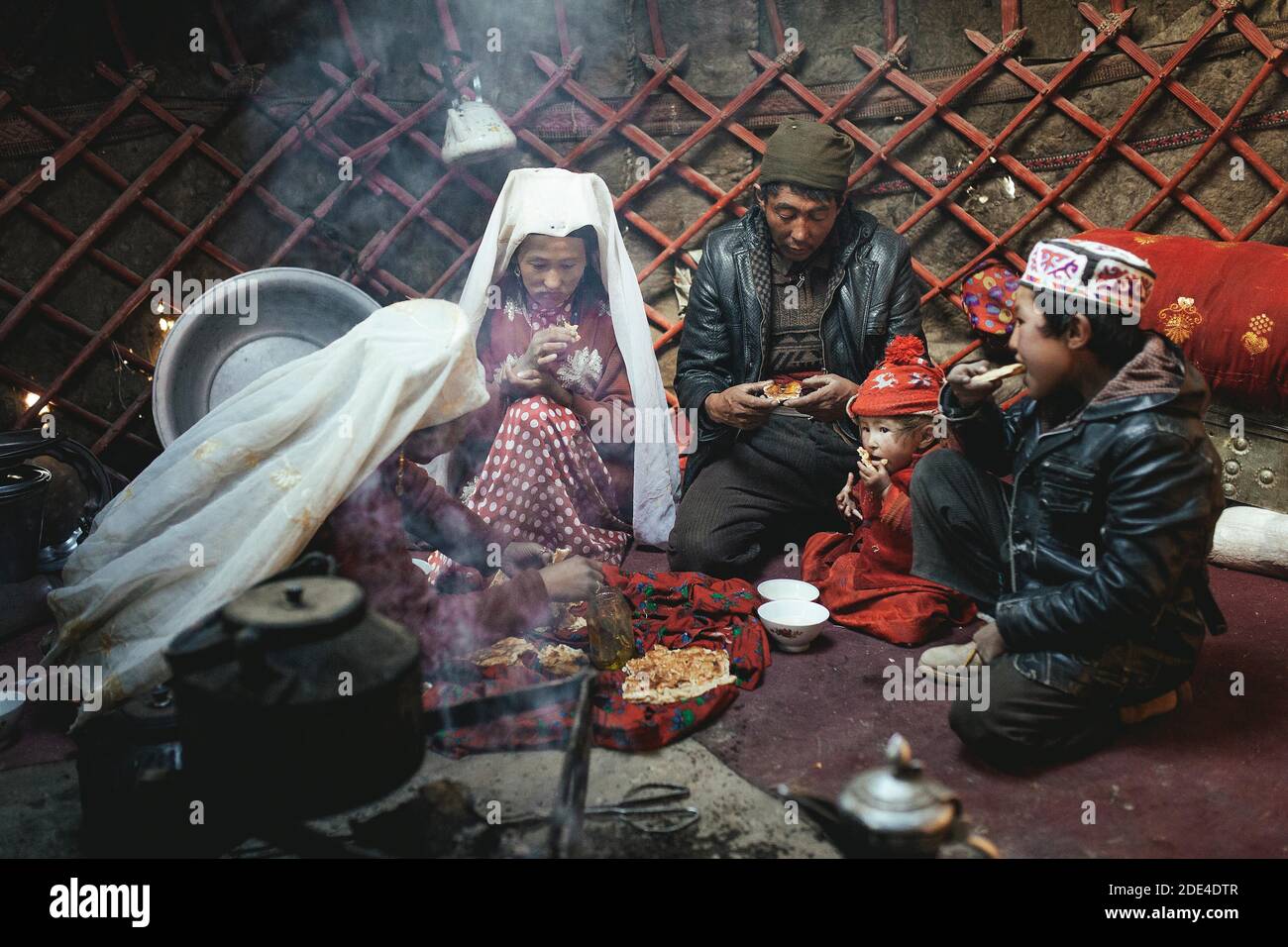 One man, two woman, two children at mealtime, nomadic Kyrgyz, yurt, Bozai Gumbaz, Wakhan Corridor, Badakhshan, Afghanistan Stock Photo