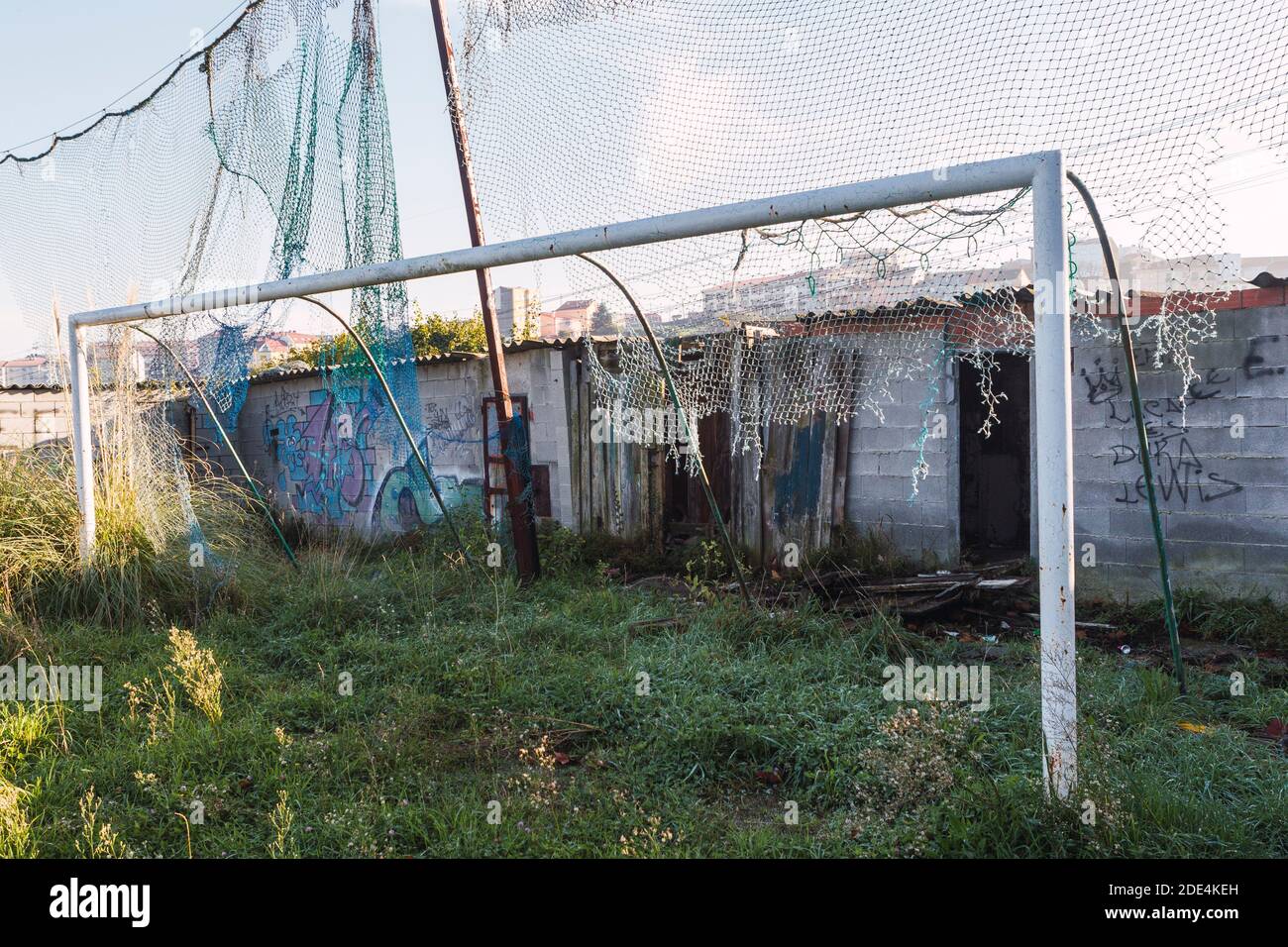 goal with broken net and abandoned wooden changing rooms with tall