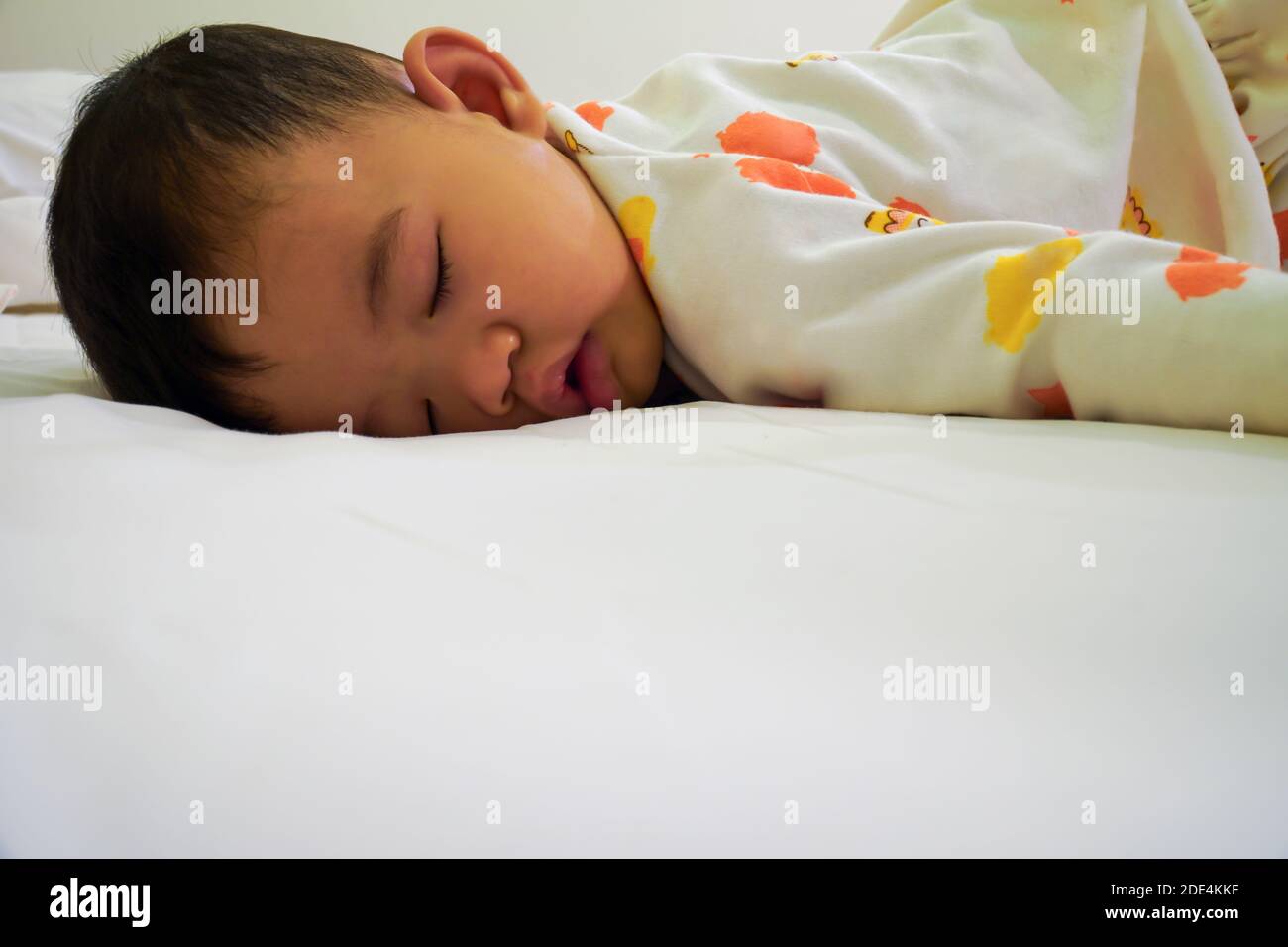 The little boy was sleeping on the bed, sleeping in the prone position