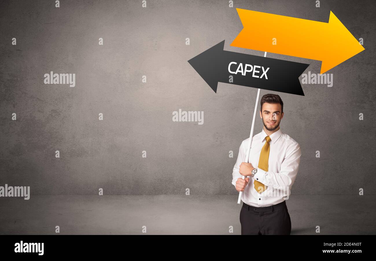 Young business person in casual holding road sign with CAPEX ...