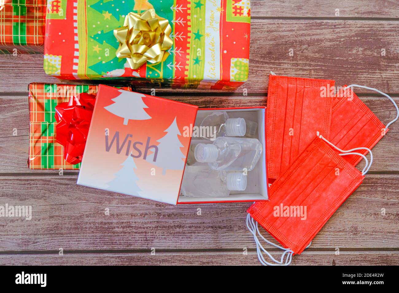 Christmas gift wrapped presents with face masks and hand sanitizer bottles Stock Photo