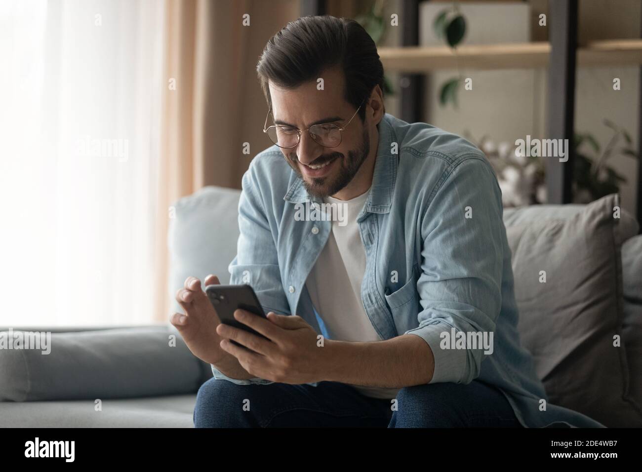 Happy young man use smartphone browsing internet Stock Photo