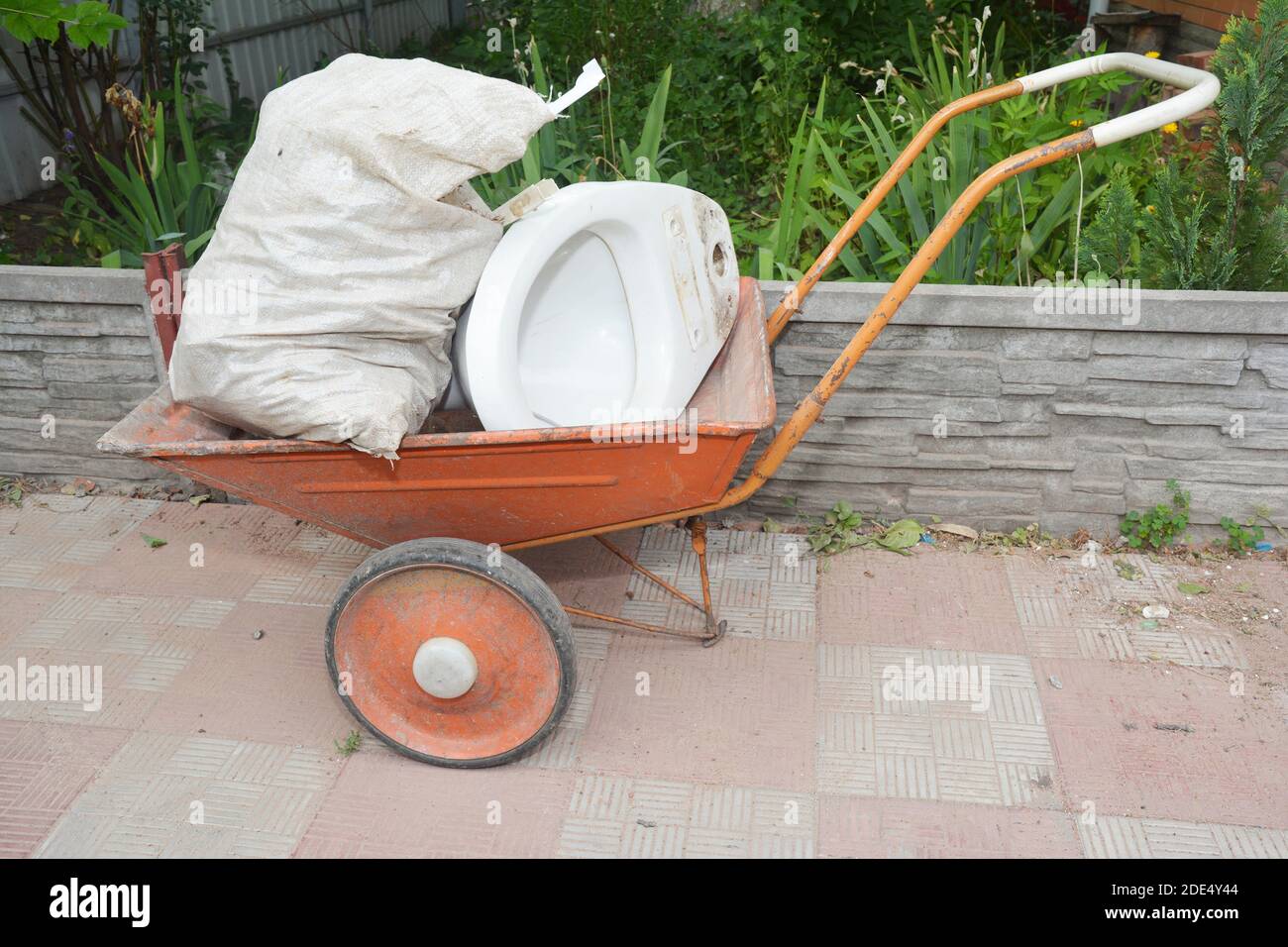 House construction garbage, toilet bowl on wheelbarrow Stock Photo
