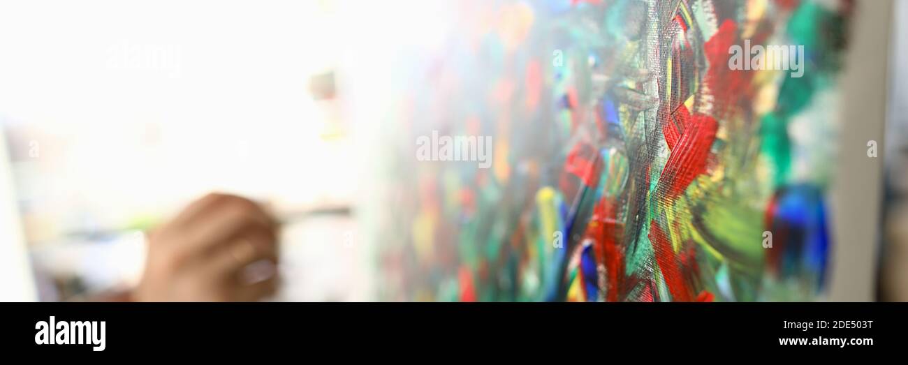 Man paints large bright abstract painting picture Stock Photo