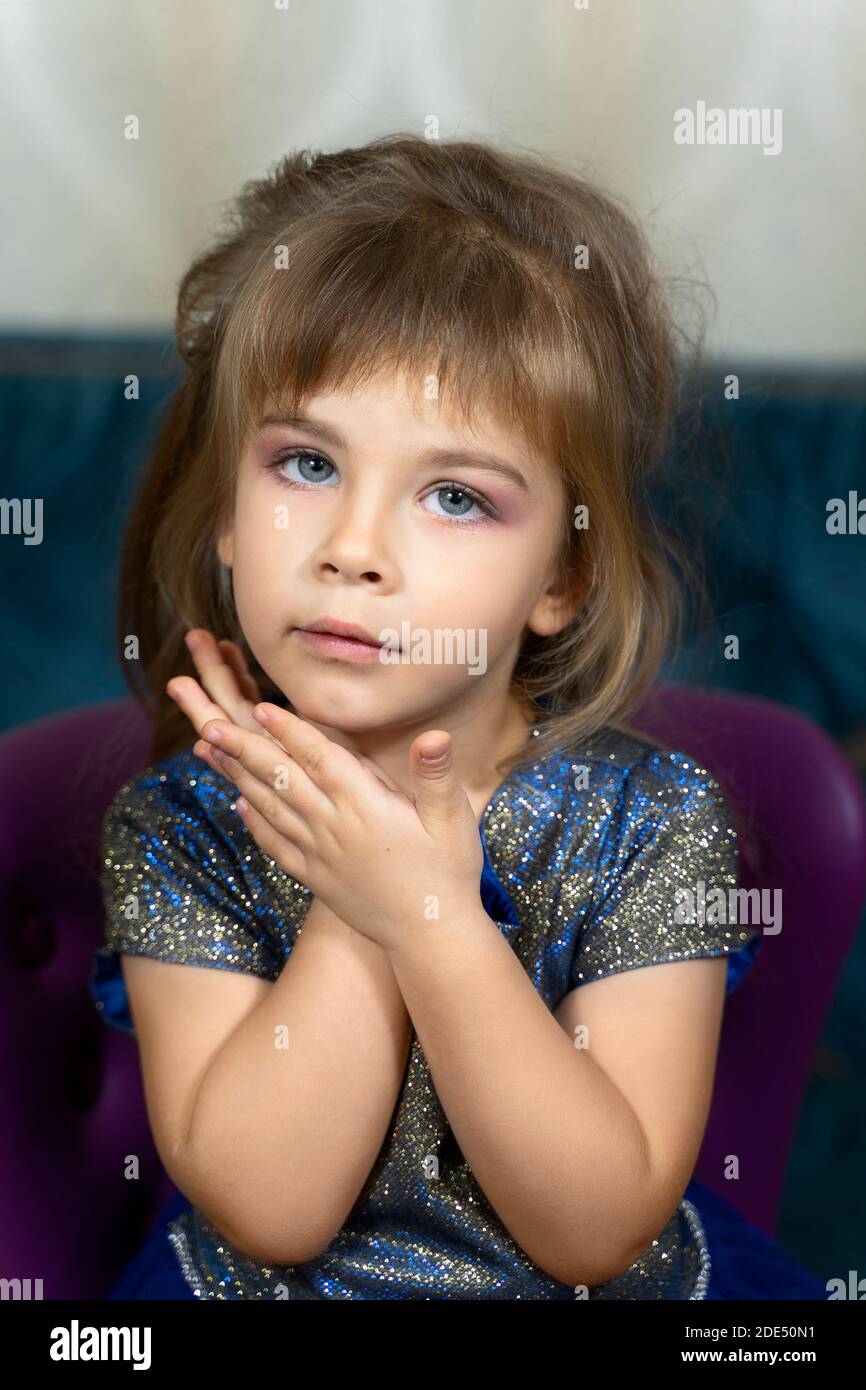 portrait of a beautiful little girl with makeup in a blue dress Stock ...
