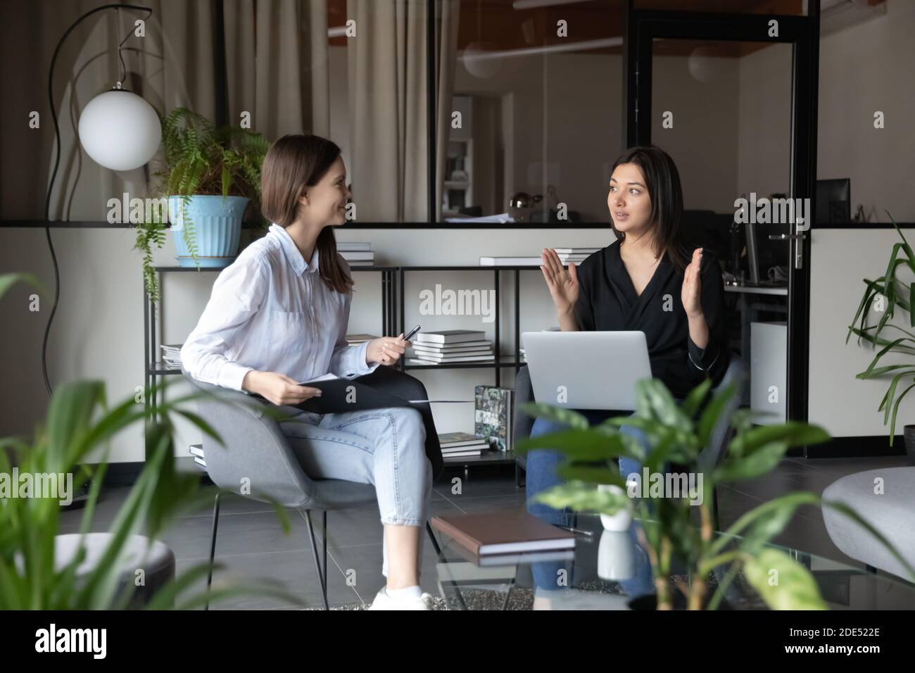 Capable young indian female mentor explaining intern corporate work ...