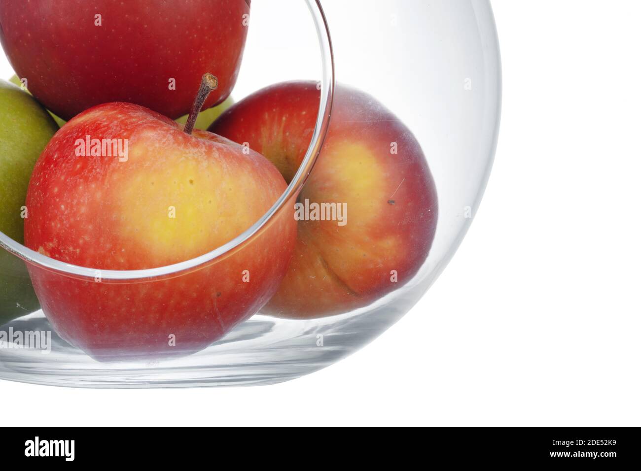 Close up of a glass fruit bowl with apples on white background Stock Photo