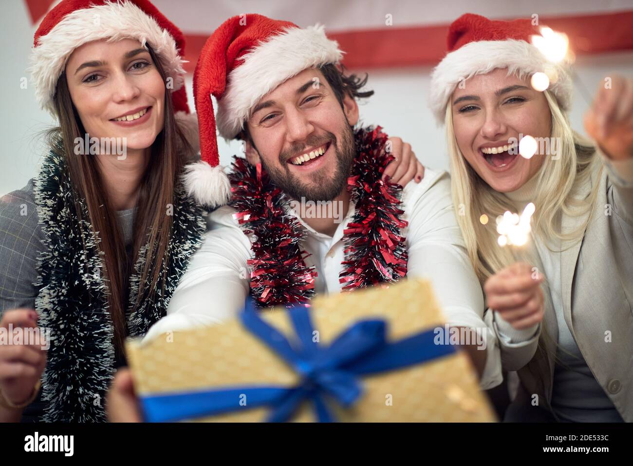 A group of cheerful friends posing for a photo at a Xmas home party in a holiday atmosphere. Christmas, friendship, together Stock Photo