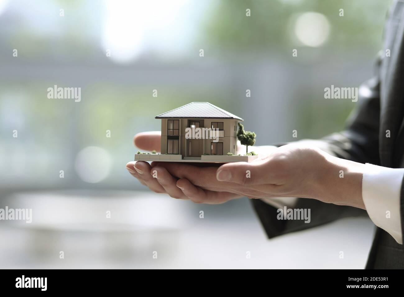 Close up of businessman holding model house. Architecture, building, construction, real estate and property concept Stock Photo