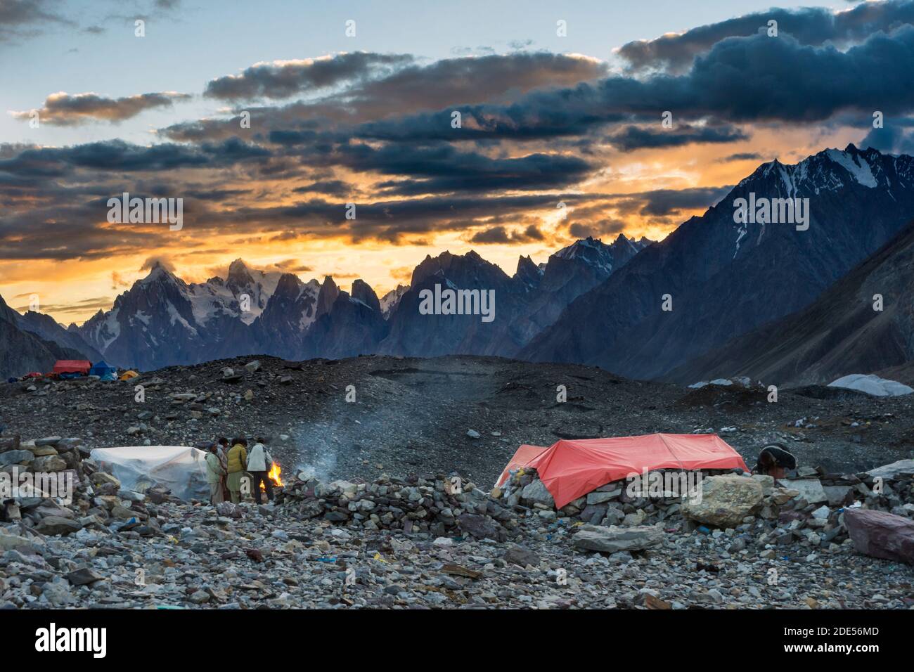 Porters next to campfire in Concordia during sunset, K2 base camp trek, Karakoram, Pakistan Stock Photo