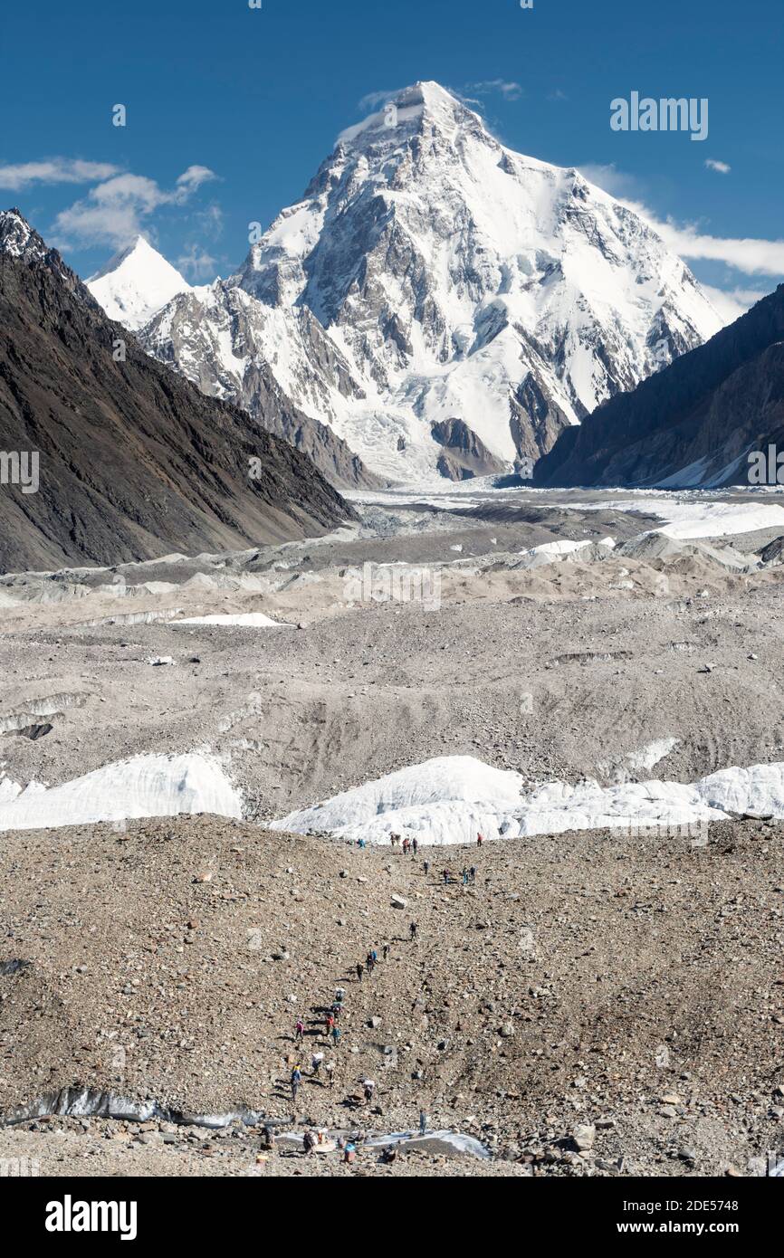 Trekkers on Baltoro glacier in front of K2 mountain, K2 base camp trek, Karakoram, Pakistan Stock Photo