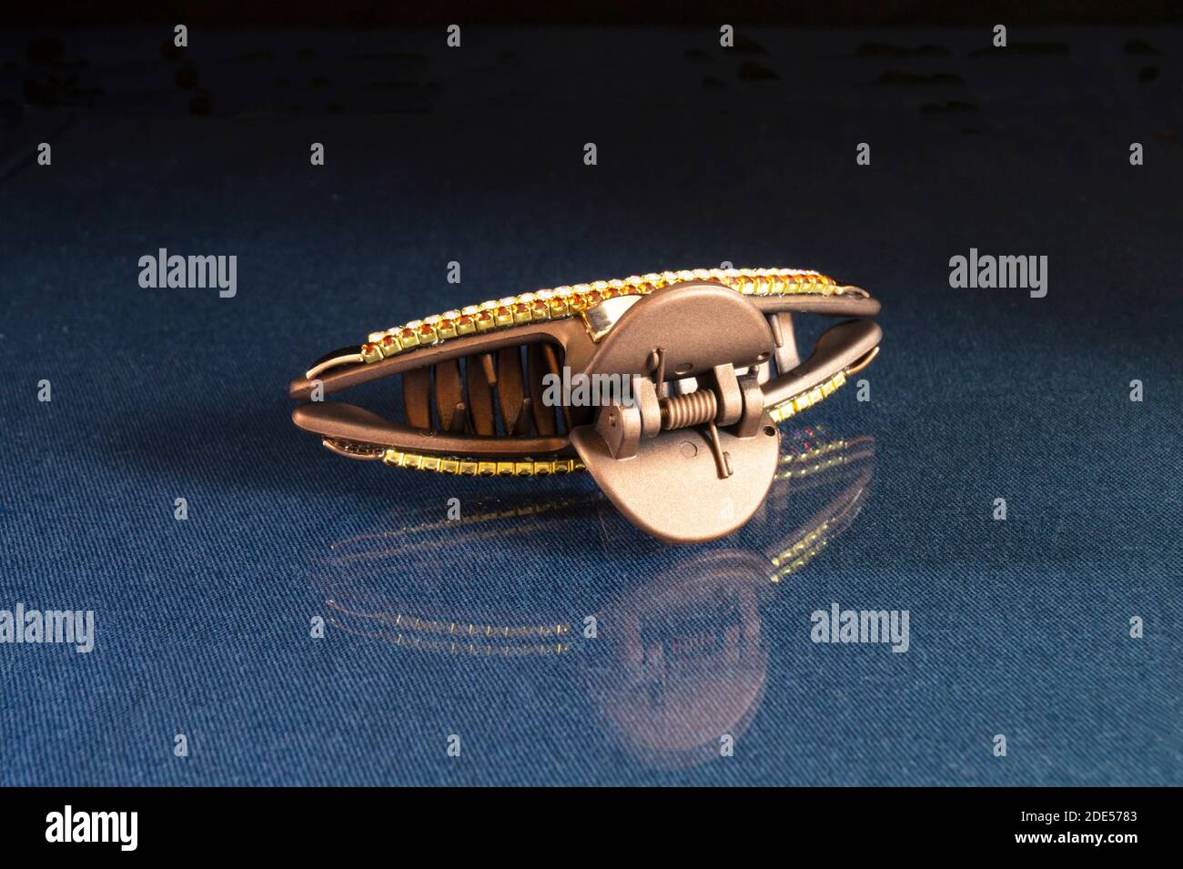 The Hair clip. The Pin for hair on turn blue the table with reflection. Personal subjects on black background Stock Photo