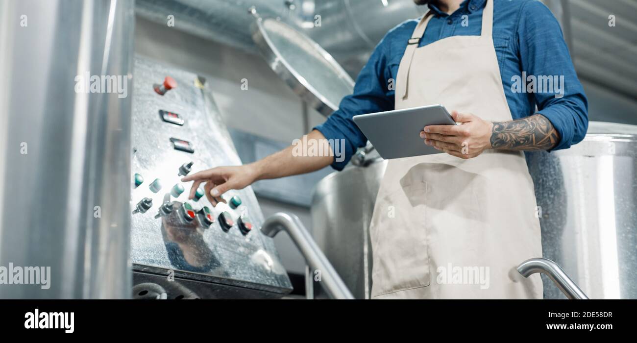 Male worker on beer factory, management and mobile app Stock Photo