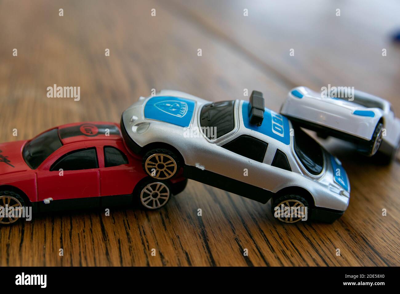 Plastic toys representing a car collision. 3 car pile up, crash, damage, insurance claim, injury, drunk driving, safety whilst driving, bad drivers, d Stock Photo