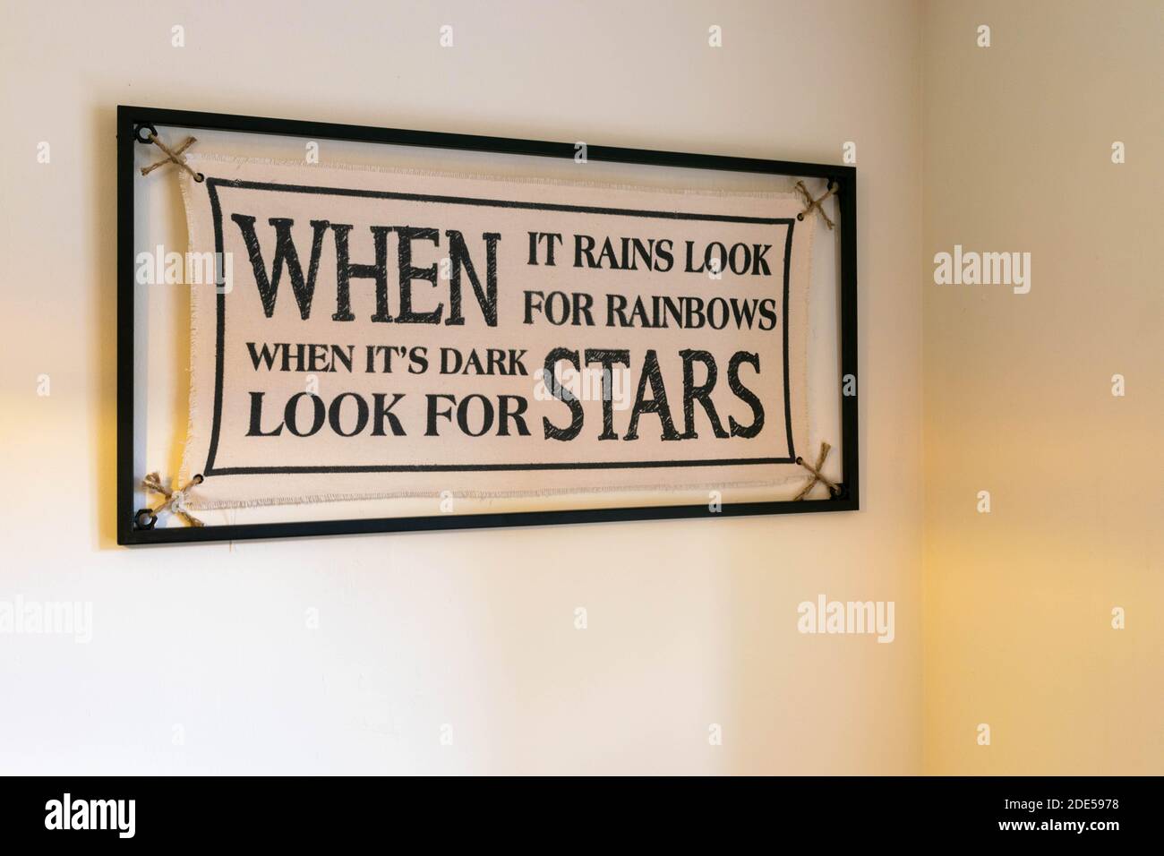 Inspiration quote When It Rains Look For Rainbows When Its Dark Look For Stars. Minimalistic  canvas held by a metal frame. Motivation slogan. Home Stock Photo