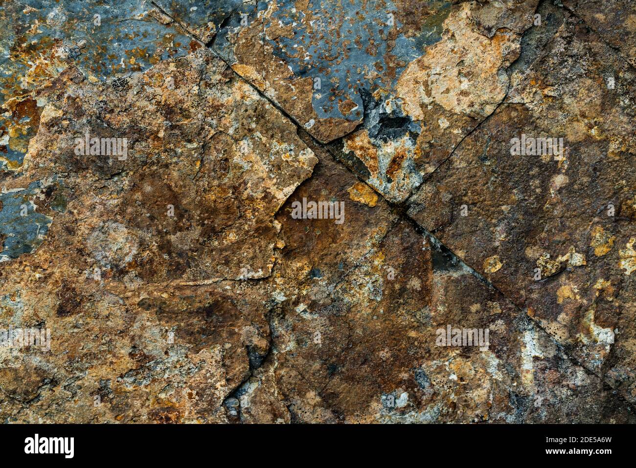 Rock wall face in various colors due to lichen, moss and rusting. . High quality photo Stock Photo