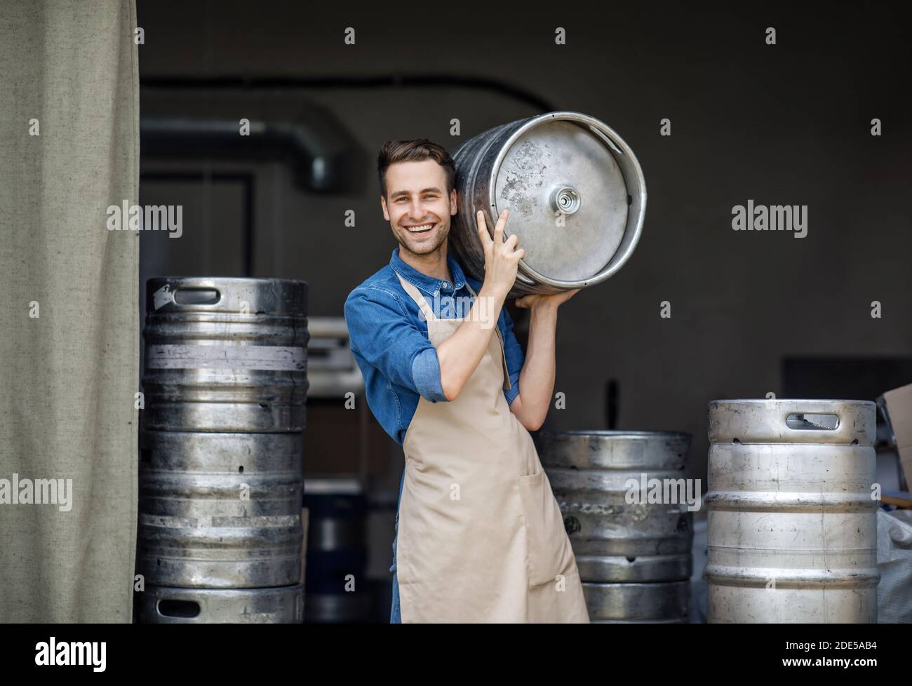 Modern brewery and worker with keg on plant, small business and beer industry Stock Photo