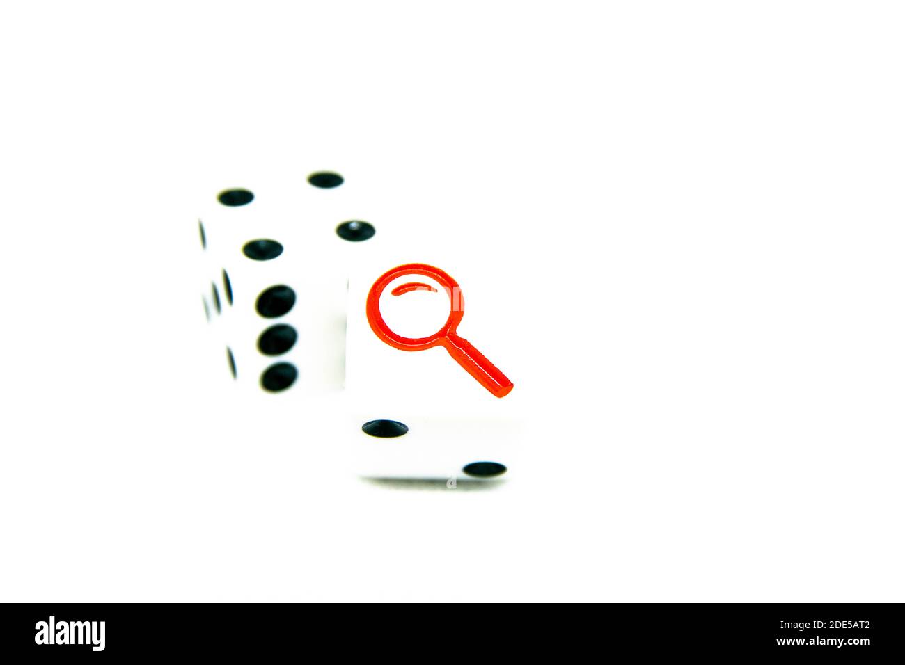 Pair of die with one showing black dots and one showing a red detectives magnifying looking glass. Isolated. Concept for mystery, strategy, luck, chan Stock Photo