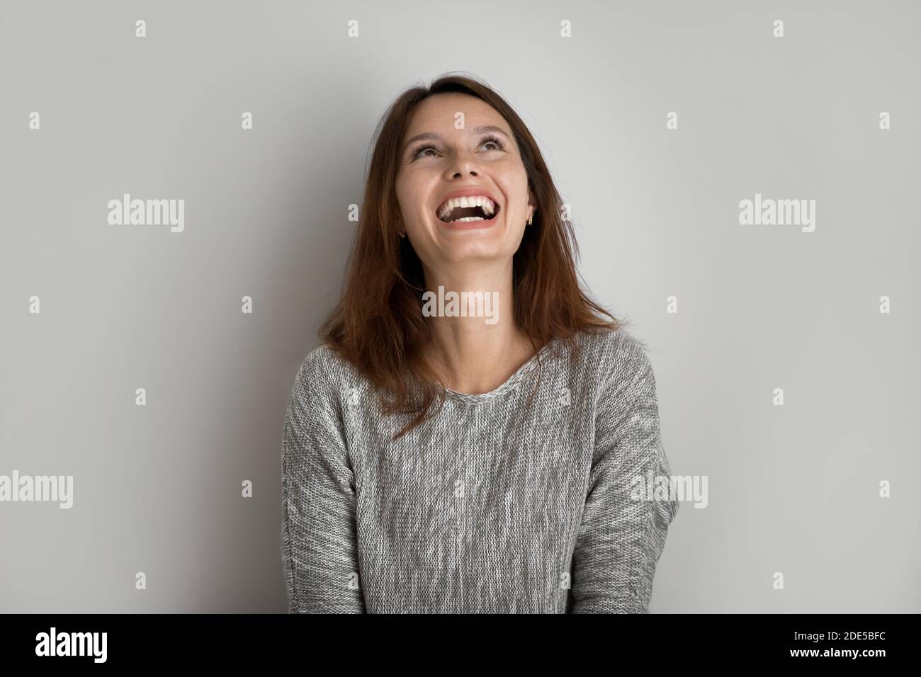 Emotional happy young woman looking up in distance. Stock Photo