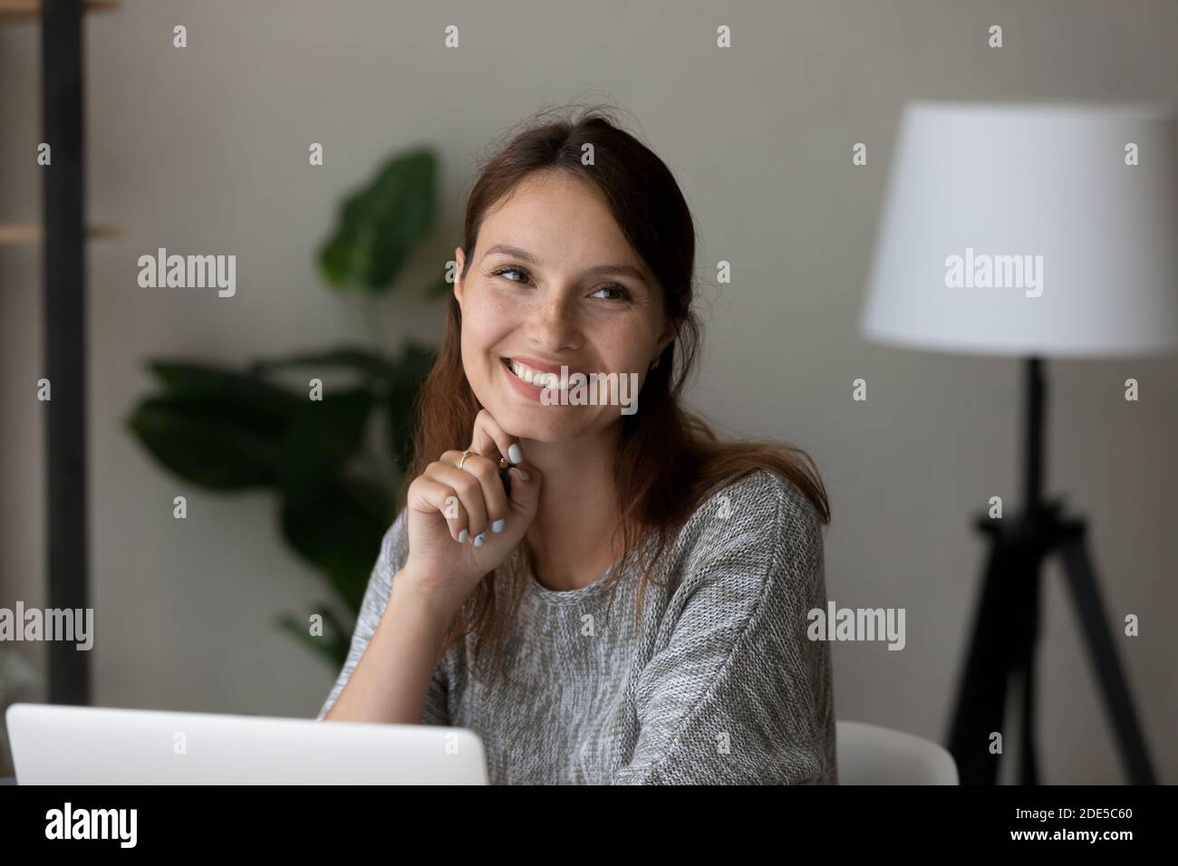 Smiling millennial caucasian woman looking away, dreaming. Stock Photo