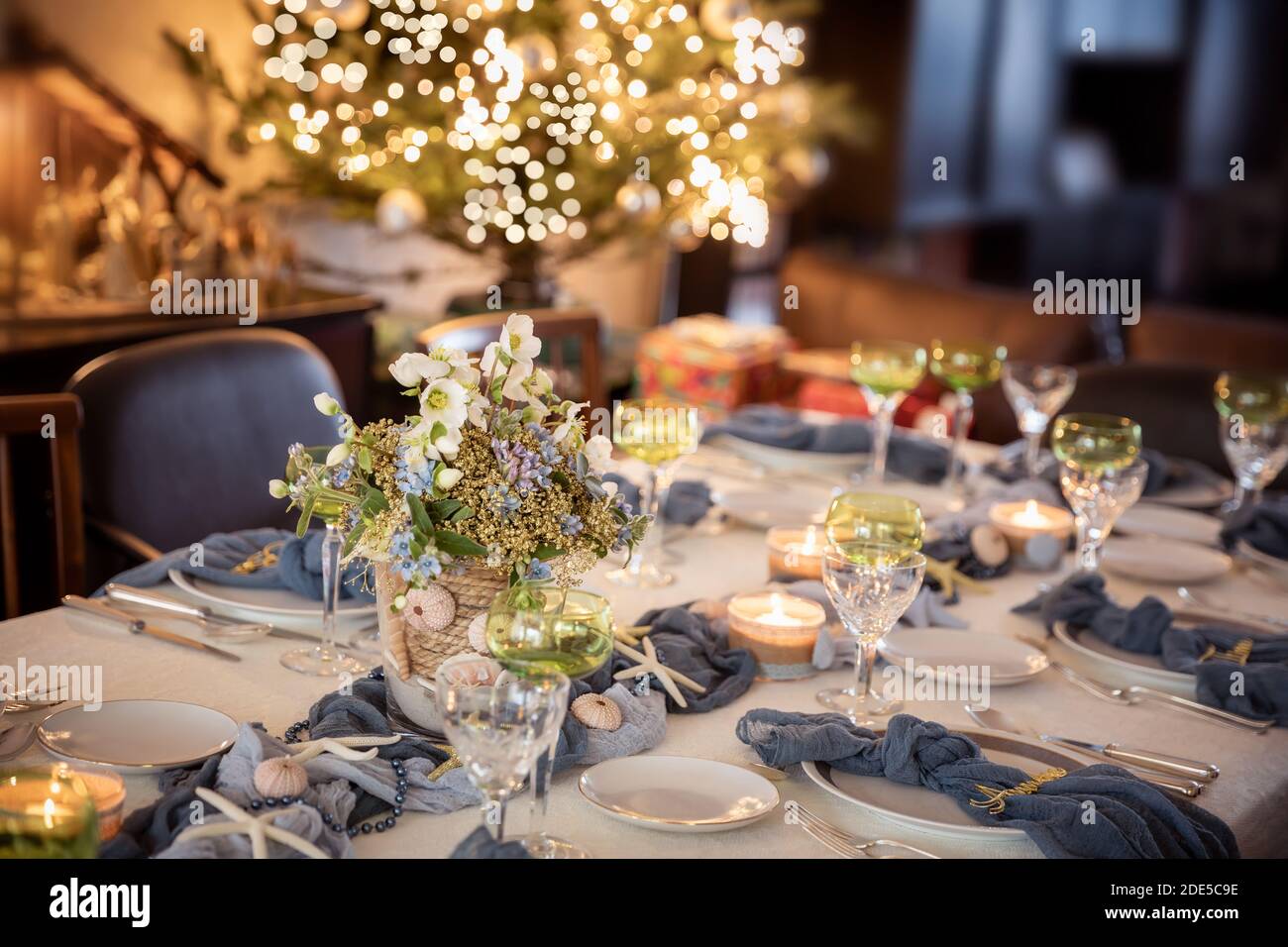 https://c8.alamy.com/comp/2DE5C9E/christmas-dinner-table-decorations-in-blues-and-gold-following-a-beach-theme-with-seashells-and-starfish-2DE5C9E.jpg