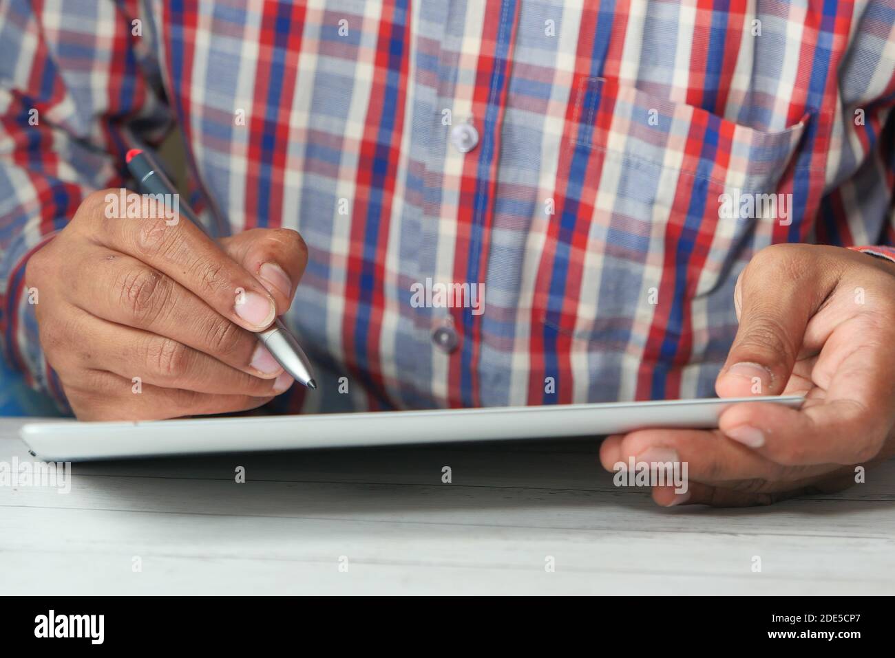 young man with pen using digital tablet on table  Stock Photo