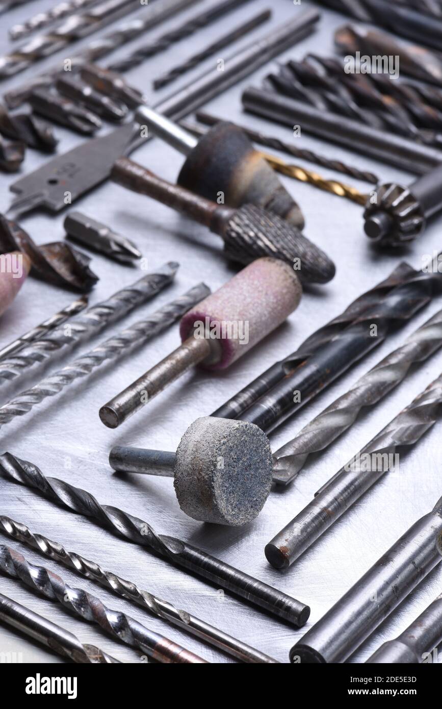 Set of drills milling cutters on grey metal surface close up Stock Photo