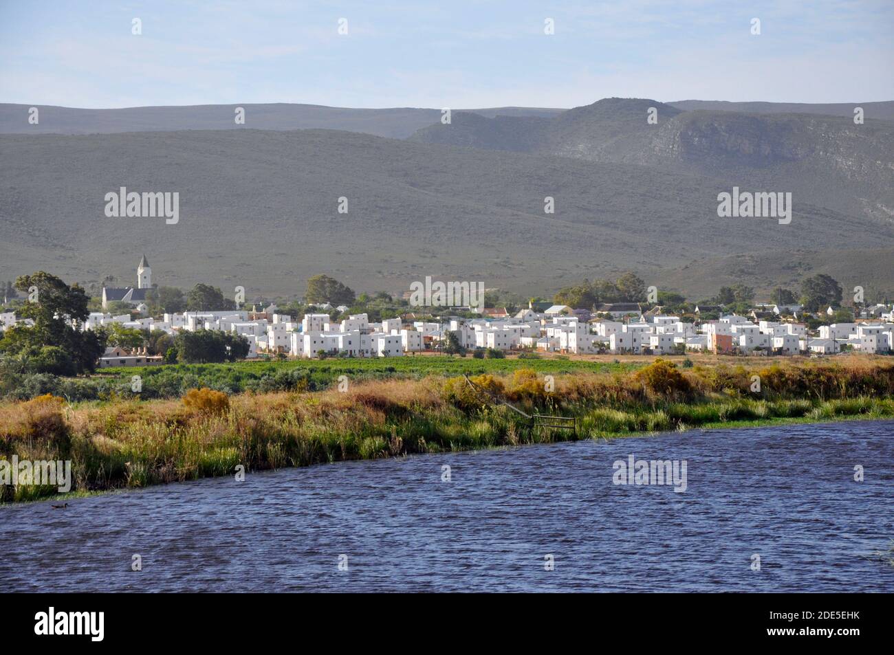 The charming, picturesque village of McGregor in the Western Cape viewed across a dam from the Stormsvlei Pass. Stock Photo