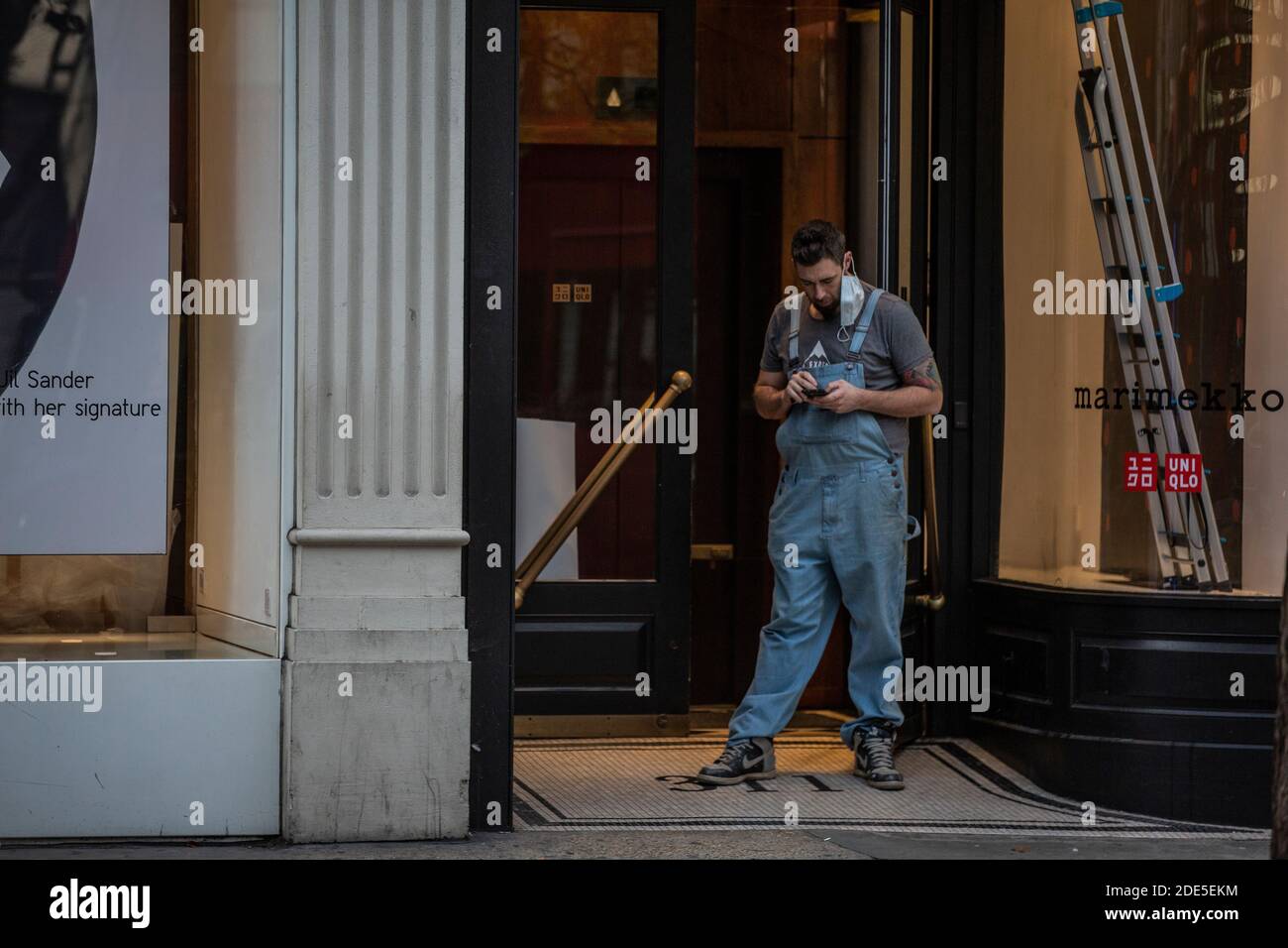 Tradesman stood in the doorway of a store being refurbished on Oxford Street during the final weekend of Coronavirus Lockdown#2, London, England, UK Stock Photo